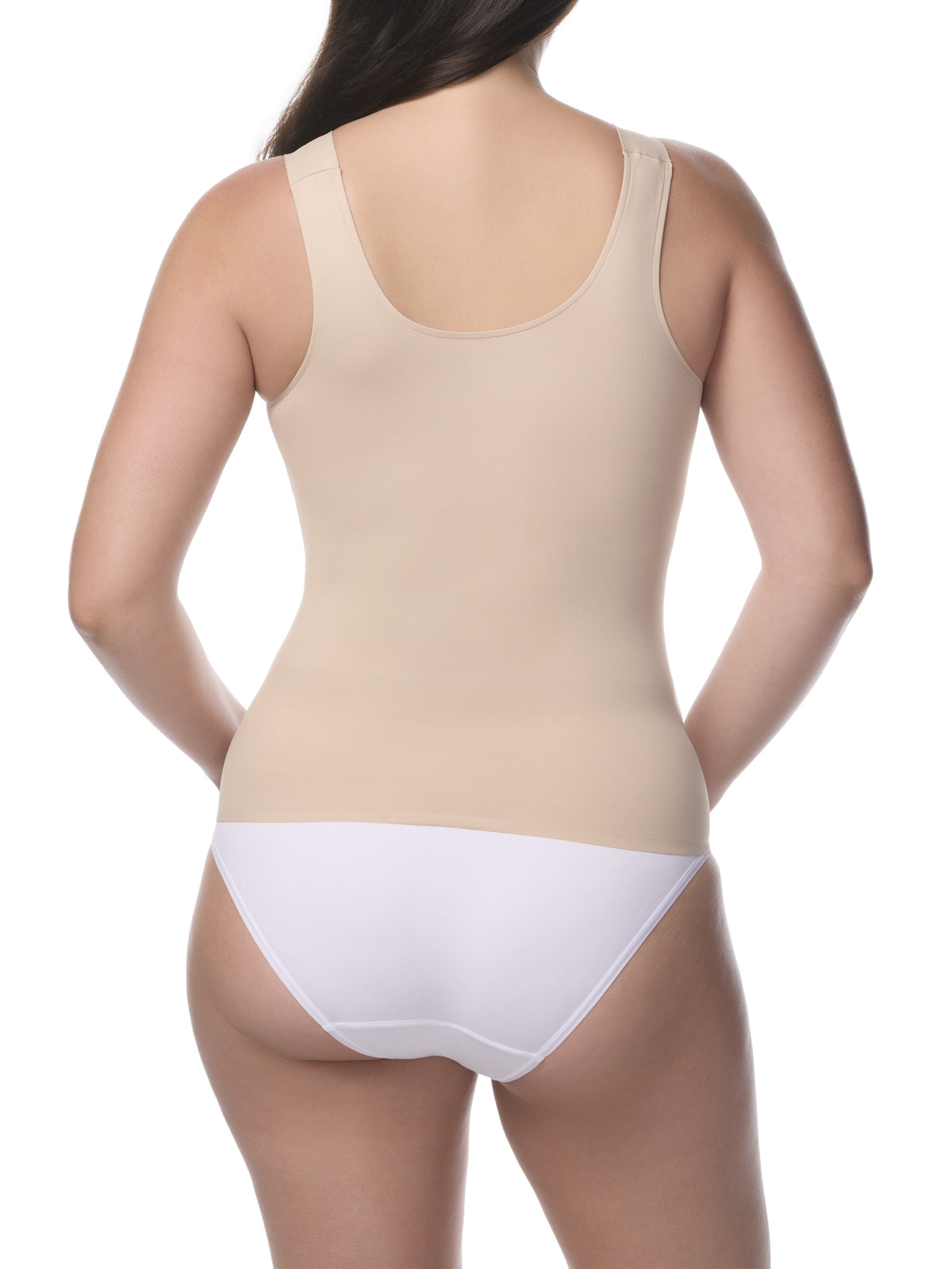 Woman wearing a beige shaping camisole and white underwear on a white background