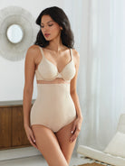 a woman standing in a living room wearing nude high waisted tummy control underwear