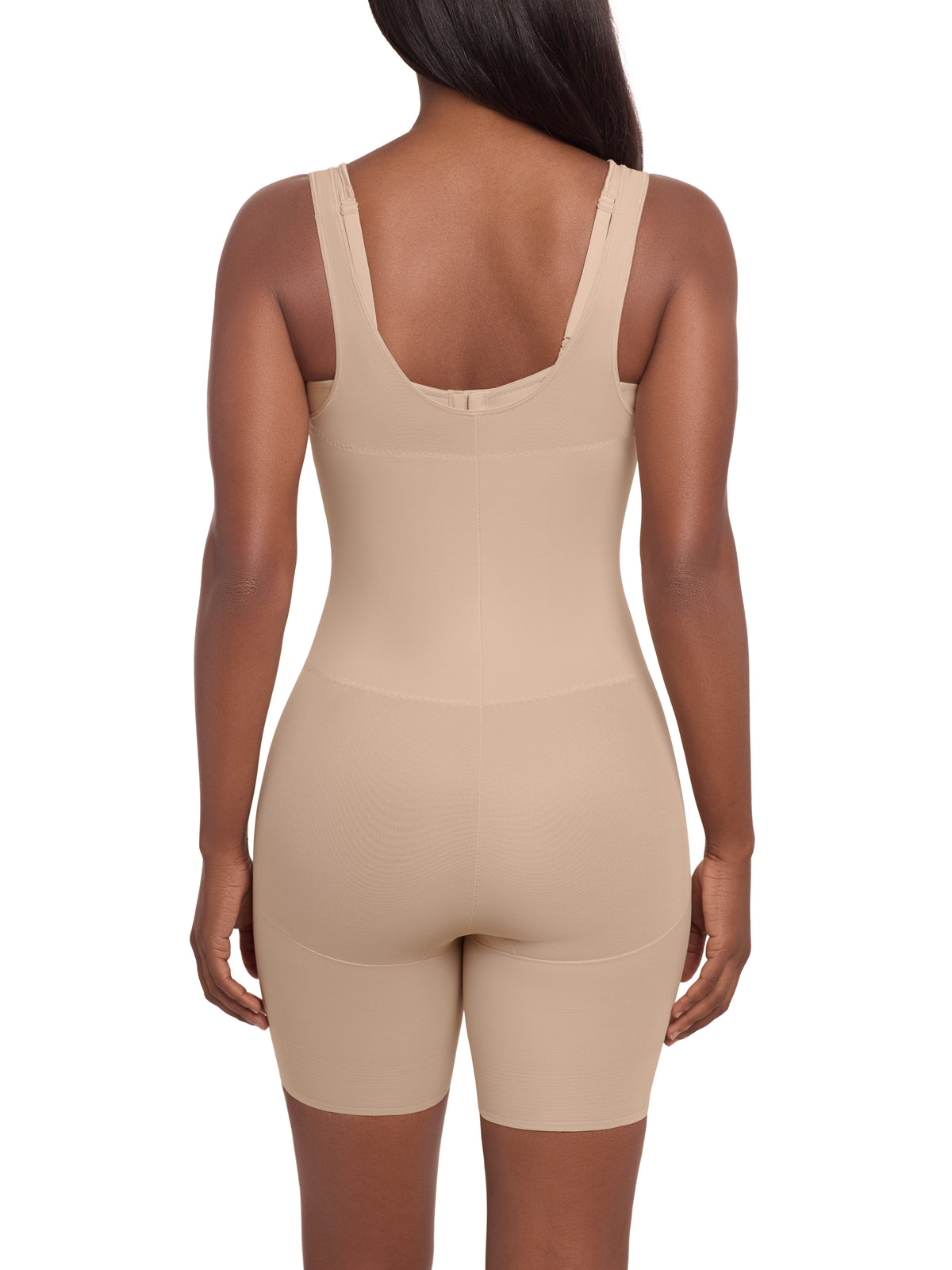a woman wearing a beige open bust tummy control shaping bodysuit full body shaper miraclesuit shapewear torsette