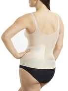 Woman wearing a beige shapewear tank top and black underwear on a white background