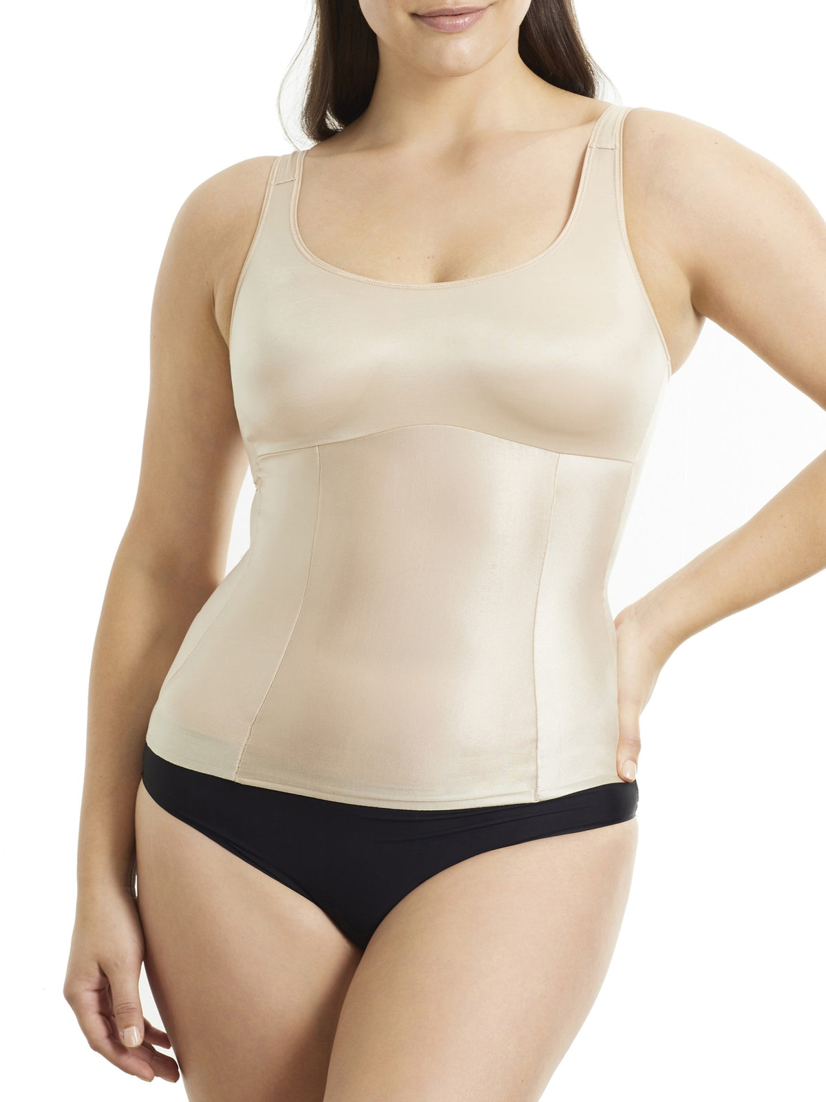 Woman wearing a beige shapewear tank top and black underwear on a white background