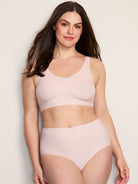 a woman wearing a pink bralette and a pink brief panty