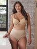 a woman waking around a kitchen while wearing a beige tummy control panty shape brief shapewear all-groups